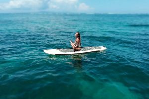 A girl paddle boarding in the Caribbean Sea, Grand Cayman