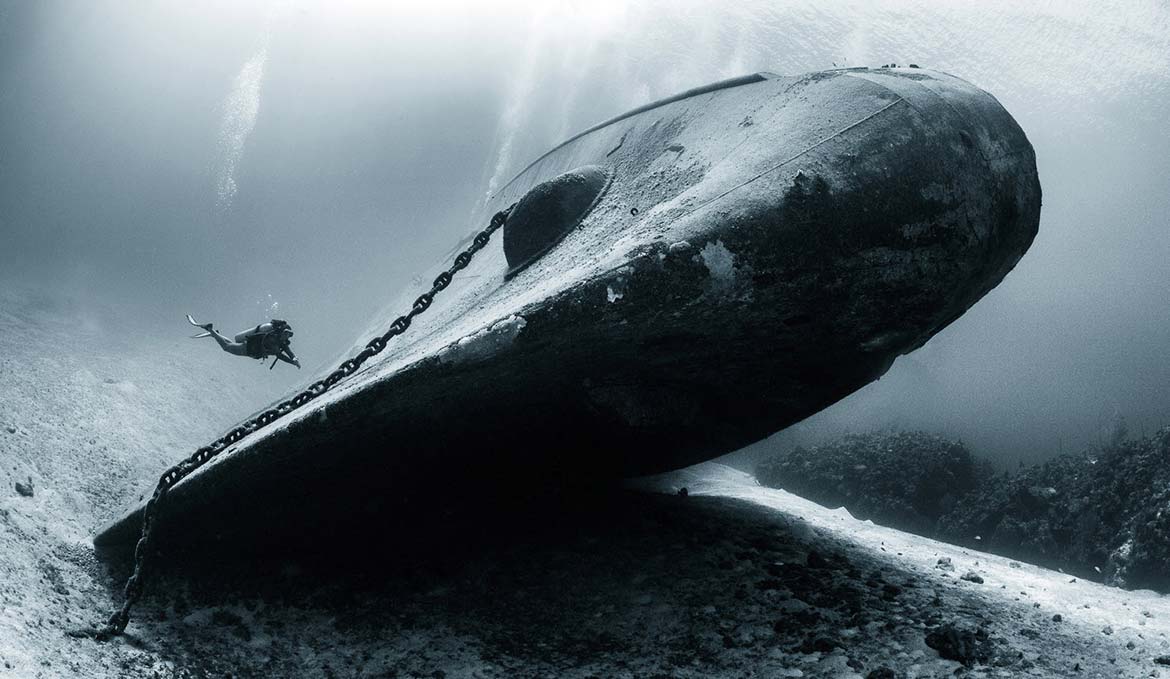 A diver approaching the U.S.S. Kittiake that as sunk deliberately as a dive attraction in the bay of George Town, Grand Cayman.