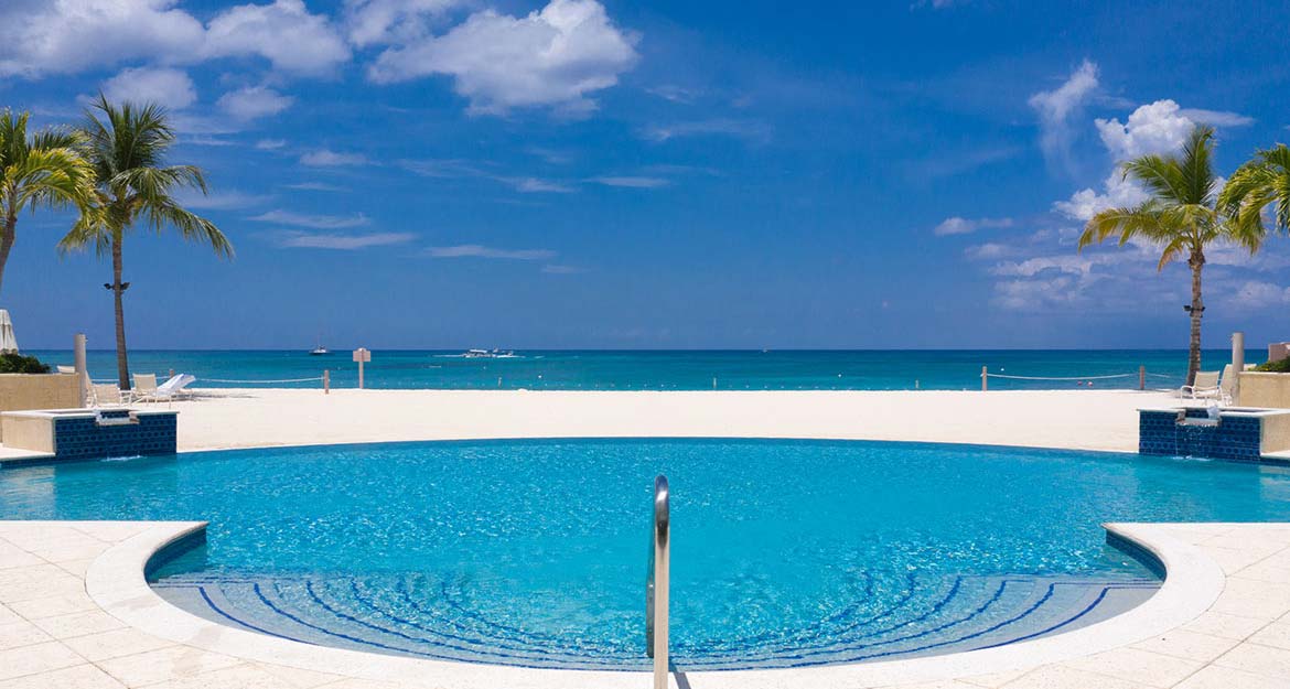 The pool at The Pinnacle on Seven Mile Beach looking out to the beach and Caribbean Sea beyond.
