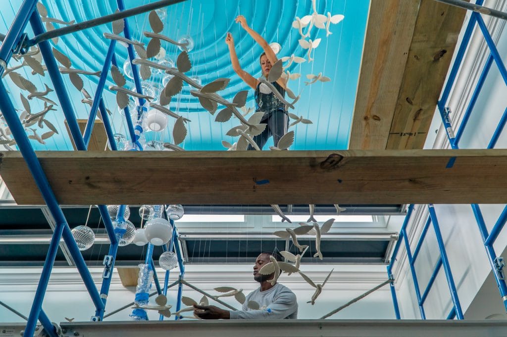 Artist Tansy Maki on scaffolding working on an art piece.