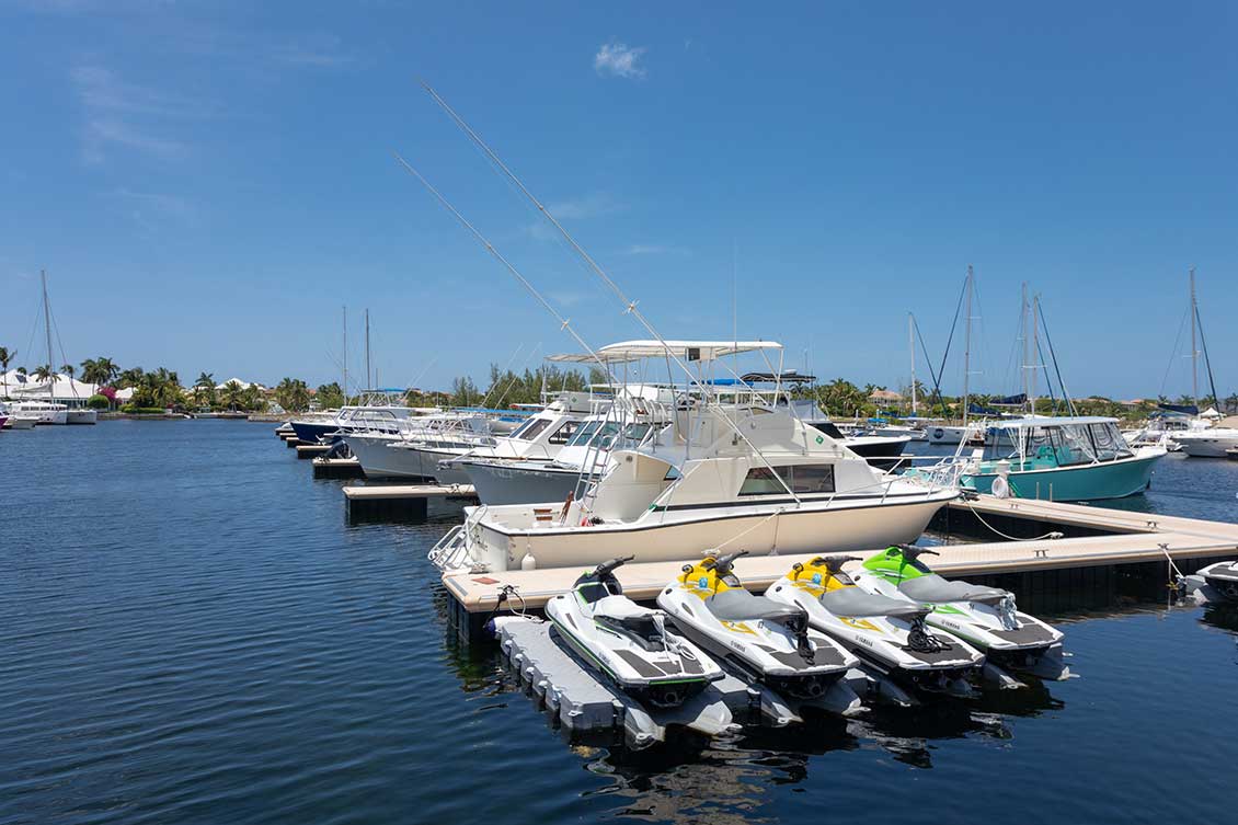 Floating dock with small boats and jet skis docked.