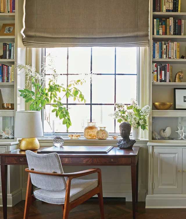A desk and chair before a bright window.