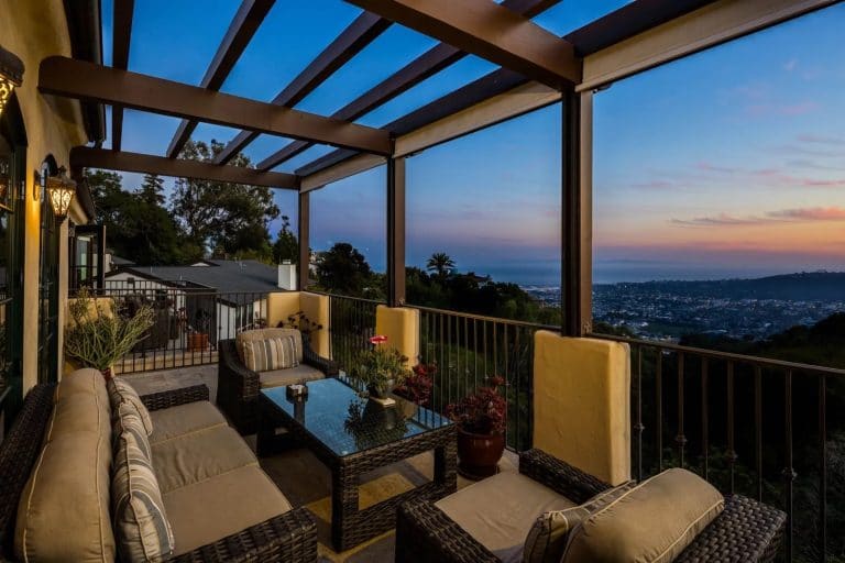 Furnished balcony at twilight with views across Santa Barbara in the U.S. to the sea.