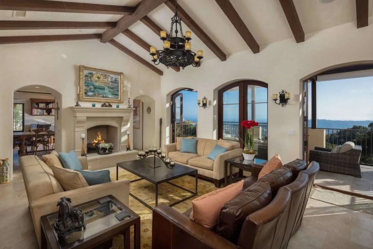 Living room with vaulted ceiling, open fire and patio doors leading out to the balcony.