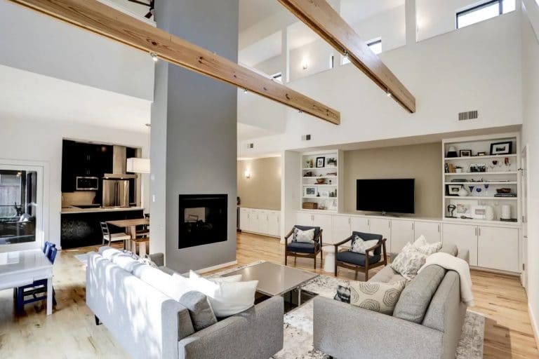 Modern living and dining area with open ceiling and stained wooden beams in Houston, Texas.