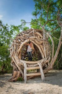 Artist Tansy Maki inside one of her bird nest sculptures.