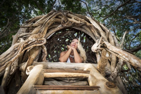 Artist Tansy Maki looking out from one of her bird nest sculptures.