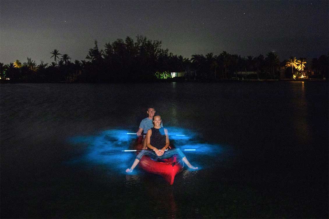 A couple kayaking through Bioluminescent Bay in Grand Cayman. 