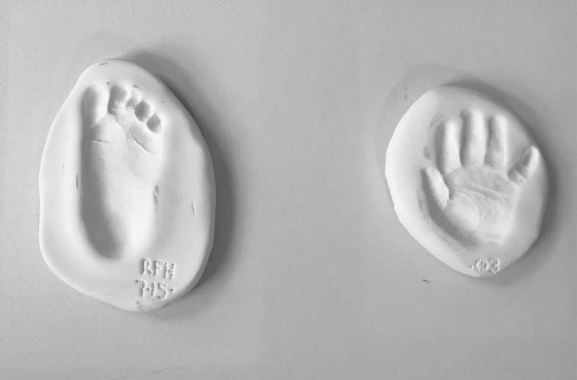Baby hand and footprints in clay of Brookes' child Rowan.