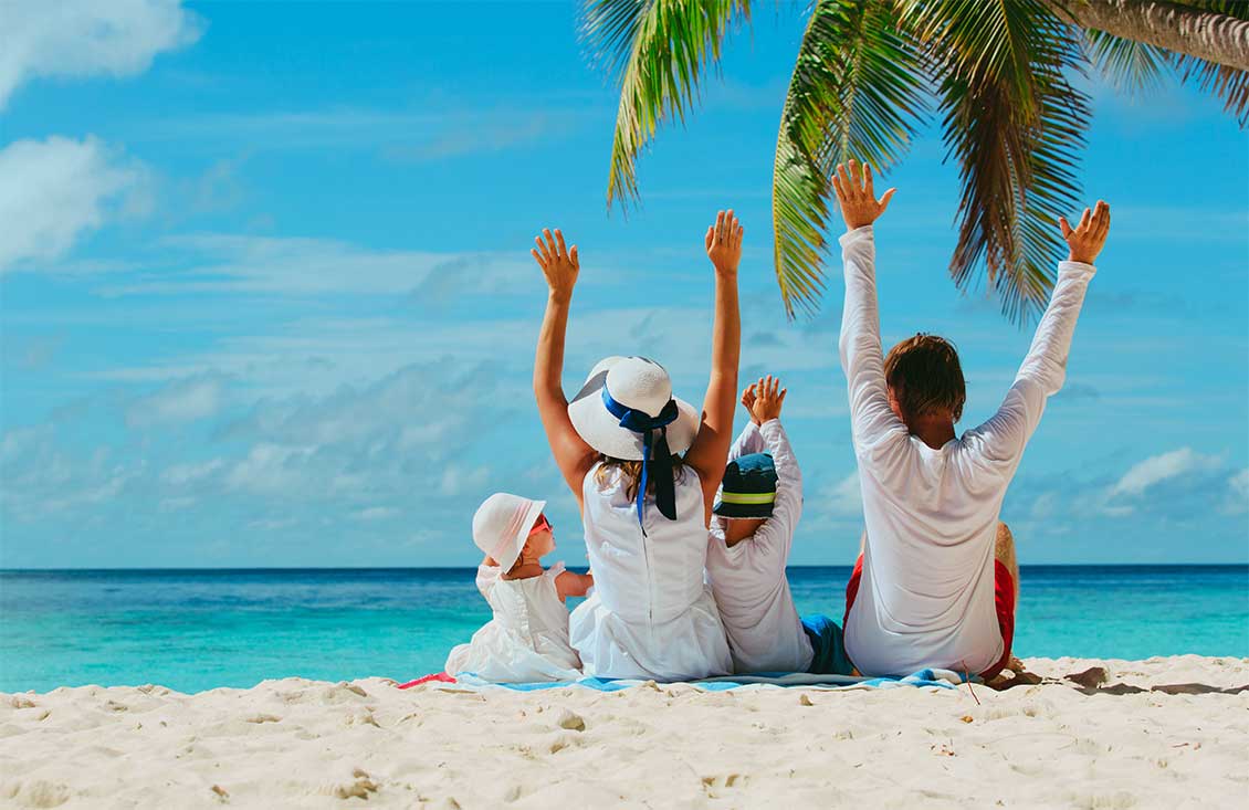 Family on the beach looking out to the Caribbean Sea.