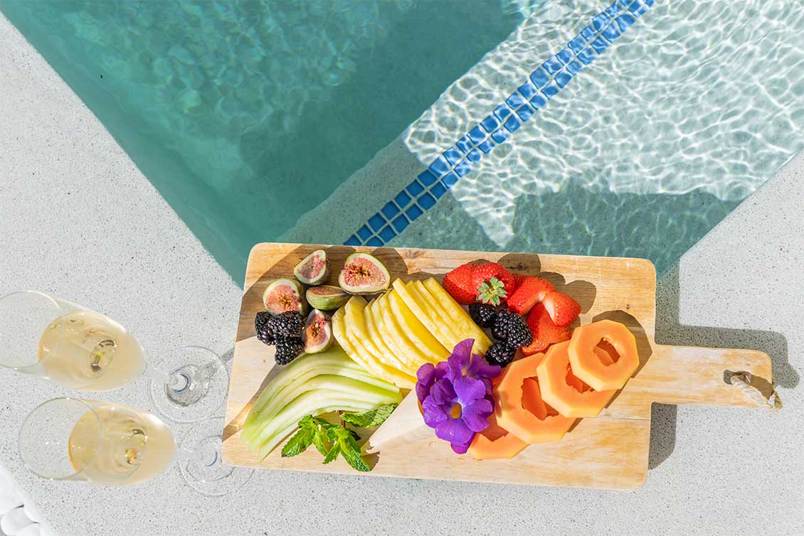 A fruit plate served with two glasses of champagne.