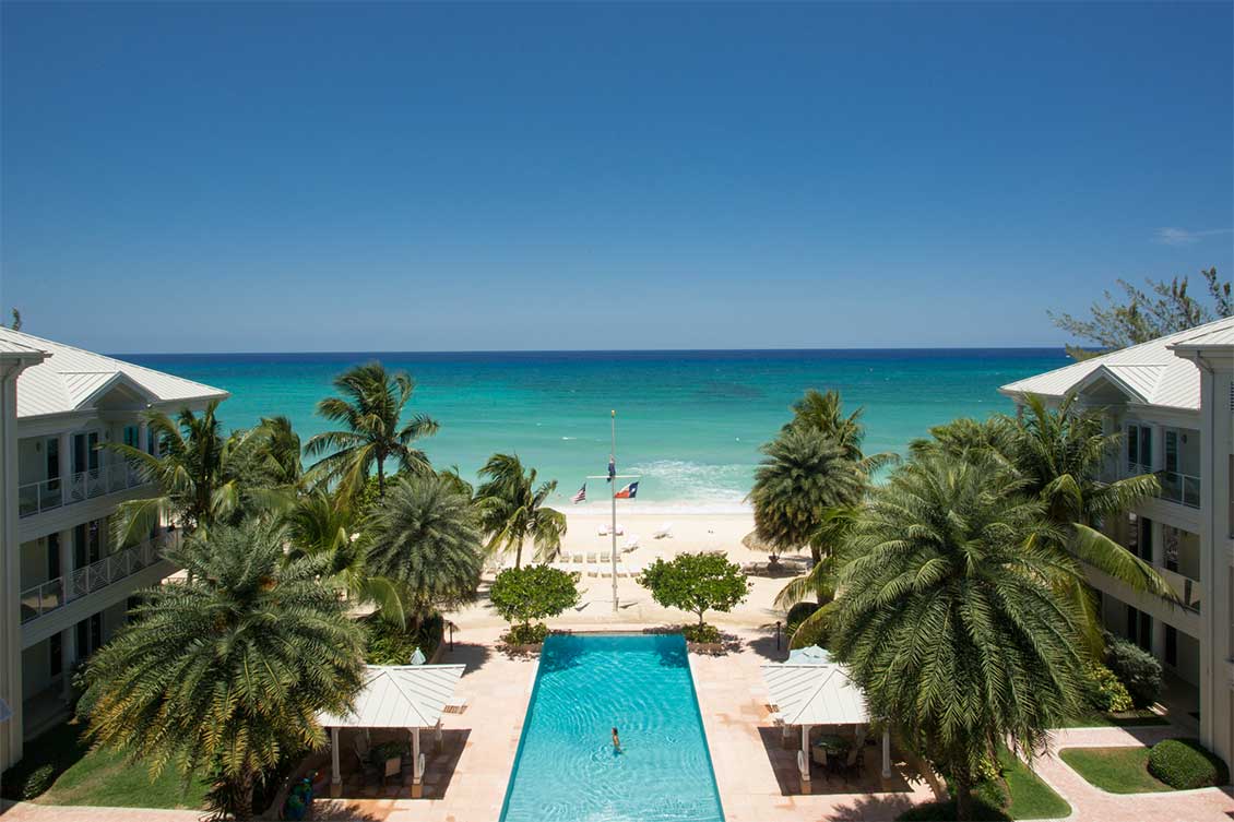 Aerial view over Caribbean Club's pool to the beach and Caribbean Sea.