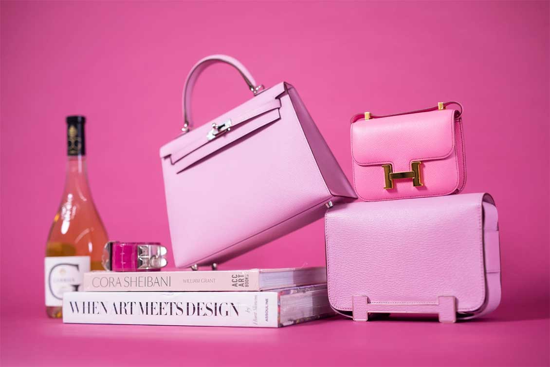 AVAILABLE FOR PURCHASE AT SOTHEBY’S: AN HERMÈS MAUVE KELLY (CENTER), BUBBLEGUM PINK MICRO CONSTANCE (TOP RIGHT) AND MAUVE GETA (BOTTOM RIGHT) WITH FUCHSIA COLLIER DE CHIEN (LEFT)