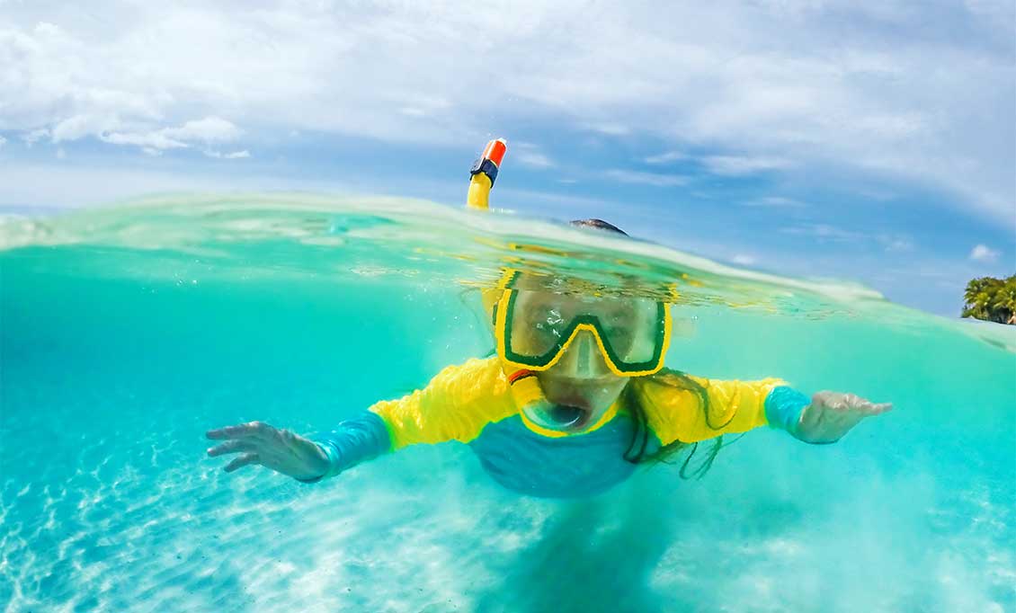A child snorkels in the Cayman Islands