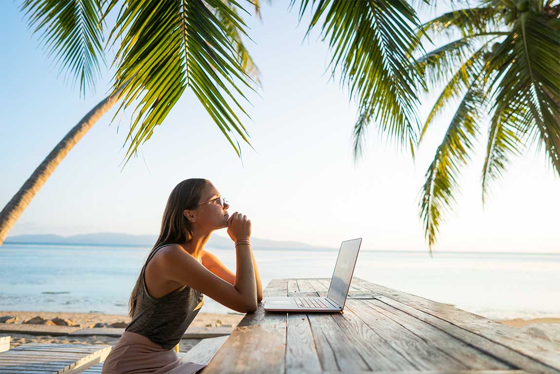 Remote worker on laptop while on Cayman Islands Beach