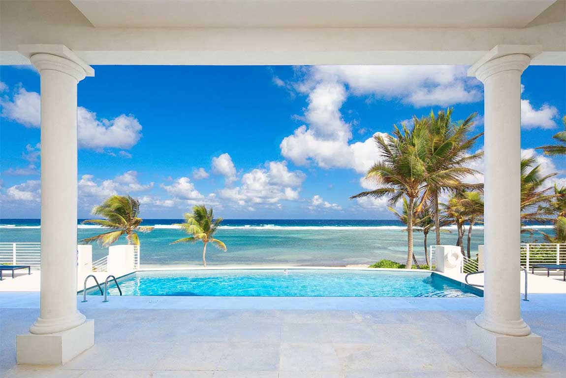 Ocean Kai's covered terrace frames an uninterrupted vista across the pool to the Caribbean Sea.