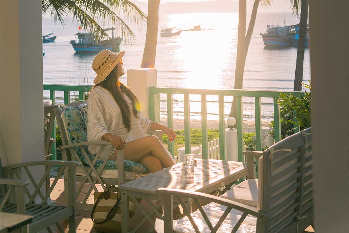 Young Woman Enjoying an Ocean View From a Tropical Veranda